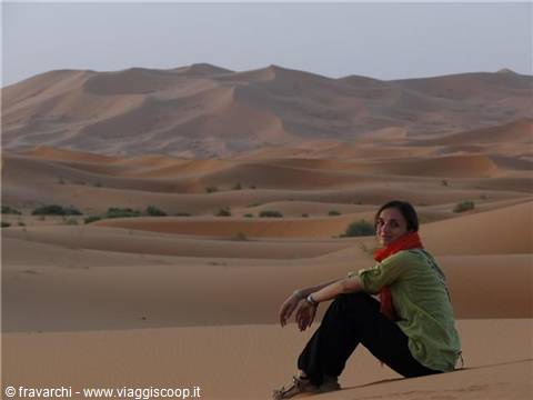 Woman sitting on the sand among the Erg Chebbi dunes