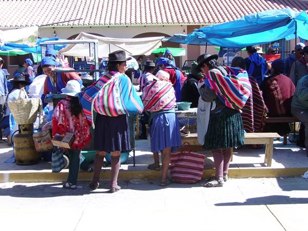Women in colorful shawls and hats at Pisac outdoor market