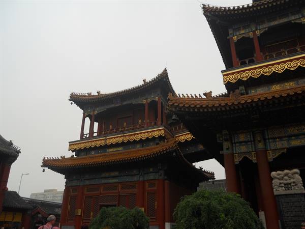 Golden-roofed pavilions of Yonghe Temple under a grey sky