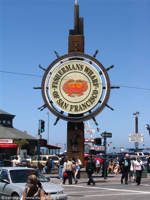 Ship wheel sign with crab at Fisherman's Wharf, San Francisco, tourists walking below