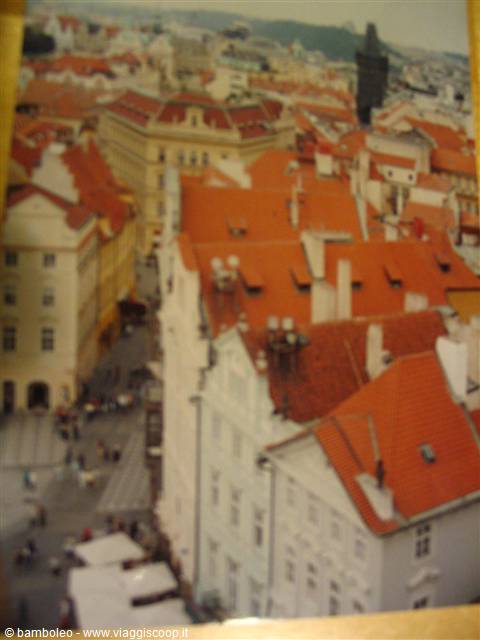 Red rooftops and old buildings over a crowded Prague square