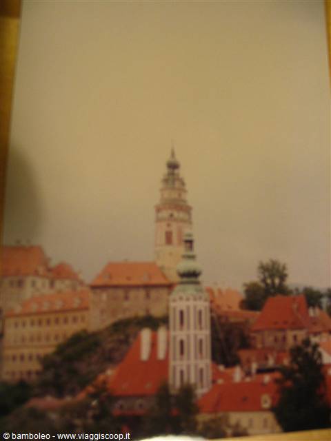 The painted tower of Český Krumlov castle above the red rooftops