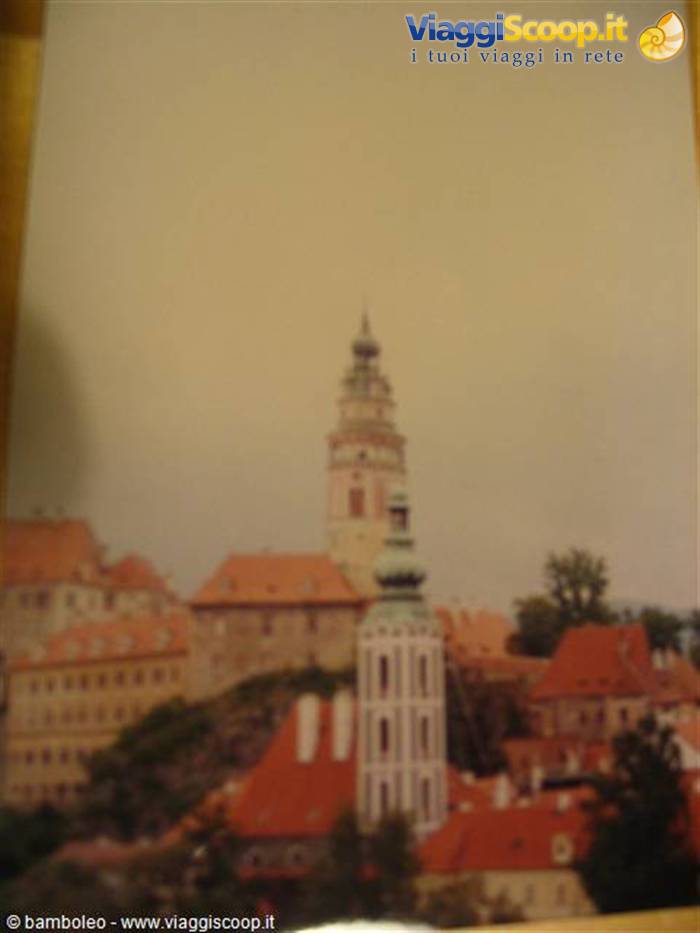 The painted tower of Český Krumlov castle above the red rooftops