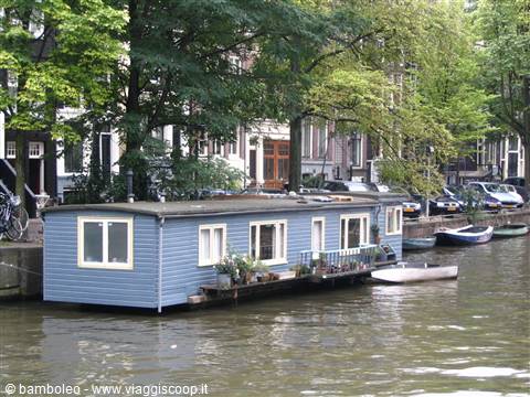 Blue wooden houseboat moored on the canal, Amsterdam, soft daylight