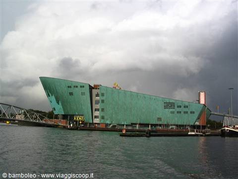 The NEMO museum in Amsterdam, green copper roof by the harbor under gray clouds