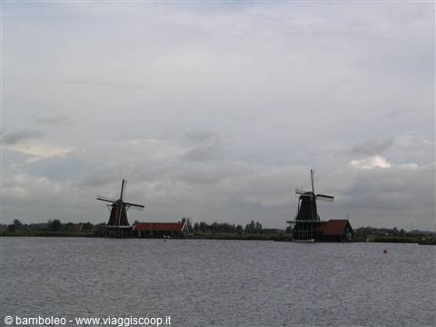 Wooden windmills along the Zaan river under cloudy sky, Zaanse Schans