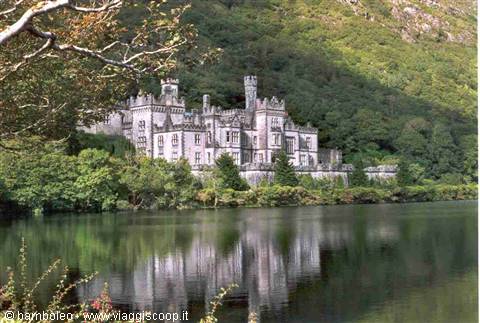 Kylemore Abbey, stone castle surrounded by woods, reflected in the lake