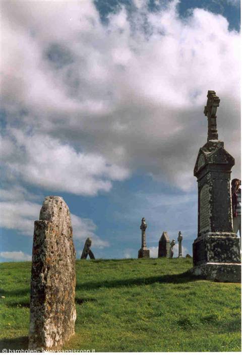 Old stone gravestones and Celtic crosses on a green hill