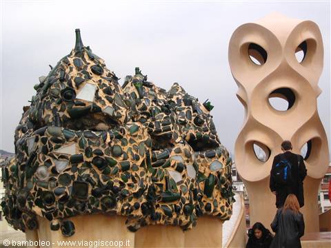 Tourists beside Gaudí's mosaic-covered chimneys on the La Pedrera rooftop