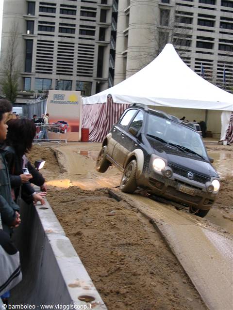 Fiat Panda 4x4 test drive on muddy track, spectators watching, white tent behind
