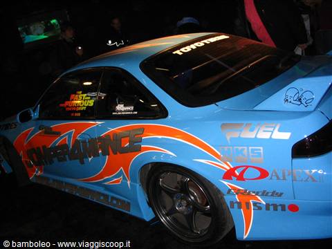 Blue tuning car with orange flames displayed at a motor show