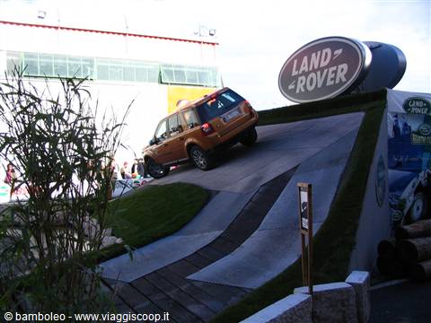 Orange Land Rover SUV tests a slope course at the motor show