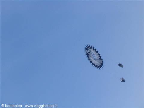 round black and white kite flying in the blue sky