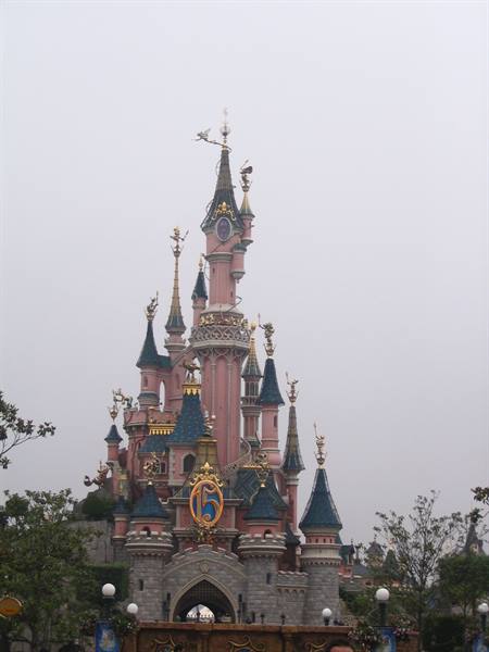Pink castle with blue spires and golden details at Disneyland park