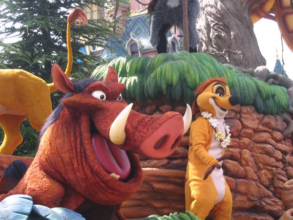 Pumbaa and Timon from Lion King at Disney park, tree float and castle