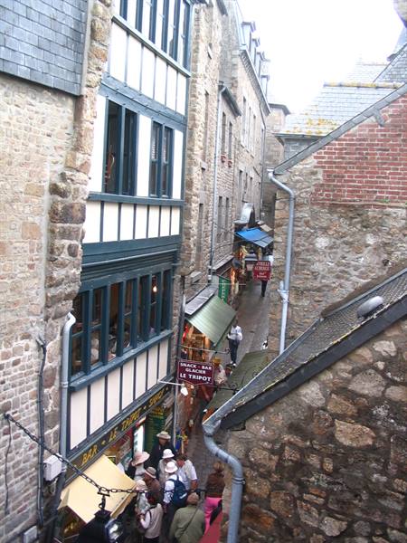 Tourists in narrow lane between medieval timber-framed stone houses, Mont Saint-Michel