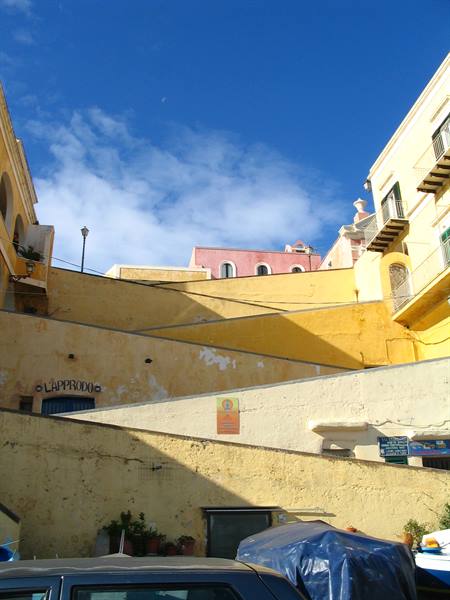 L'Approdo sign, yellow and pink houses on Ventotene ramp