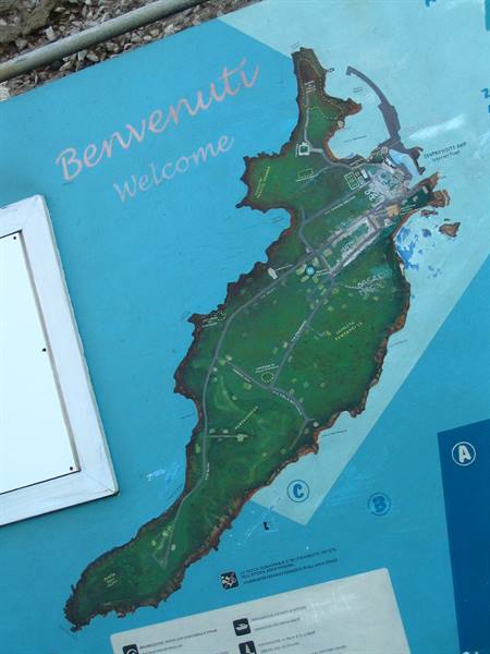 Tourist map on blue panel, green island with harbor, welcome sign