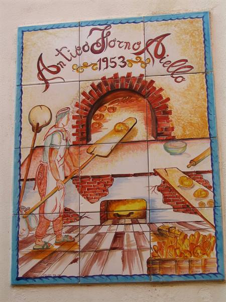 Painted ceramic tile mural: baker with peel before wood-fired oven, Antico Forno Aiello 1953