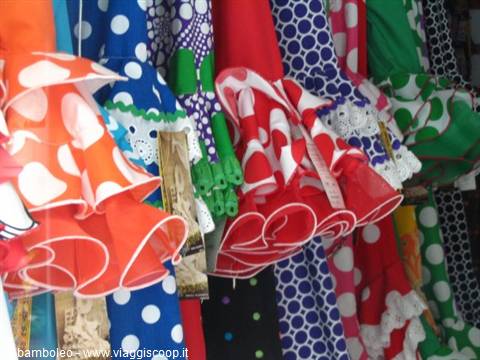 Colorful polka-dot flamenco skirts hanging at a market stall