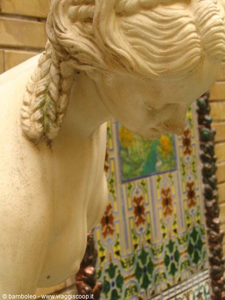 Marble statue with braided hair before decorated majolica tiles