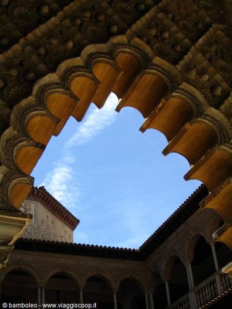 Carved wooden mudéjar arch over a monastery cloister arcades