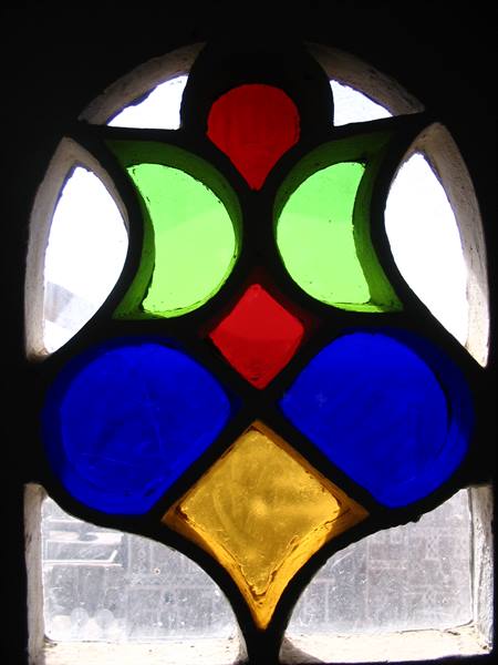 Arched stained glass window with red, green, blue and yellow panels