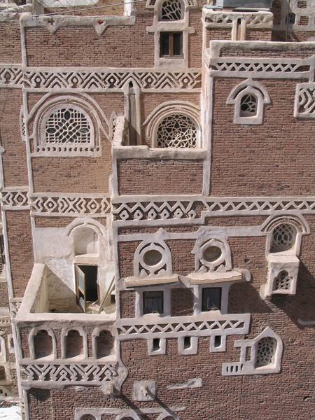 Red brick facades with white gypsum decoration and latticed windows, Sana'a