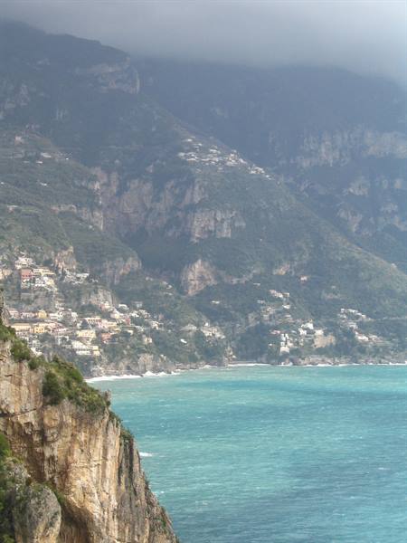 Amalfi Coast: colorful houses on misty mountains, turquoise sea, rocky cliff