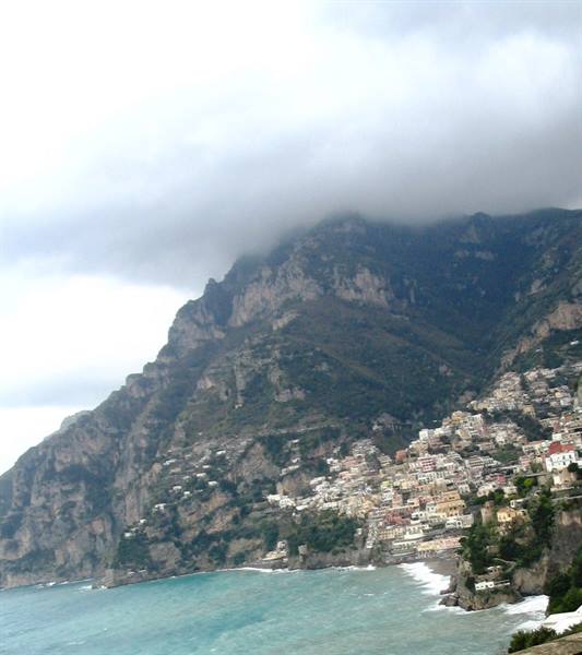 Positano's colorful houses beneath the mountain shrouded in clouds