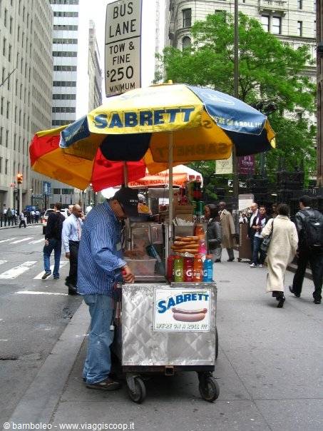 Street vendor at a Sabrett hot dog cart under the yellow umbrella, New York