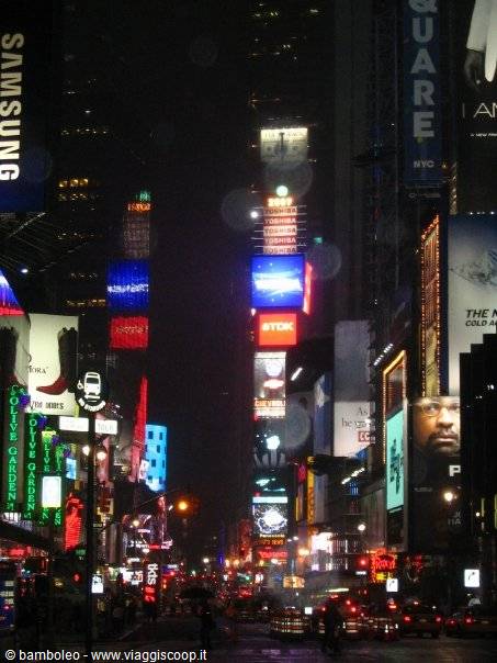 Times Square at night, glowing billboards and skyscrapers covered in ads