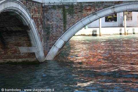Istrian stone arches and bricks of a bridge over a Venice canal