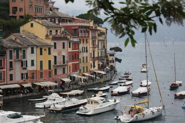 Boats moored in Portofino harbor in front of colorful houses