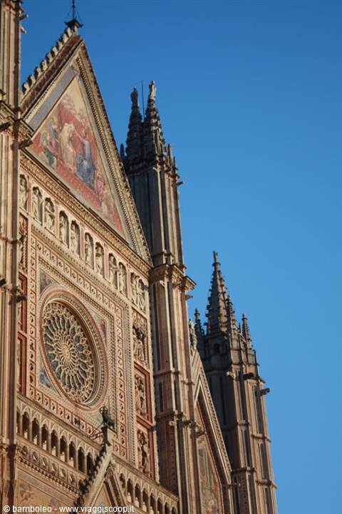 Orvieto Cathedral facade with golden mosaics and rose window in sunlight