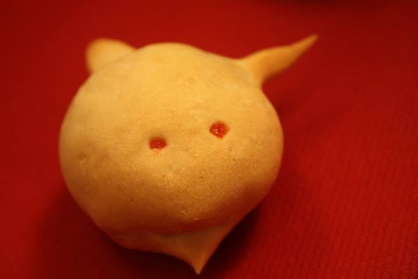 Animal-shaped pastry with red eyes, resting on a red tablecloth