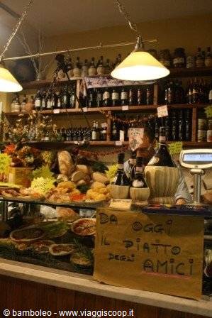 Deli counter with ready dishes, wine bottles and glowing yellow lamps