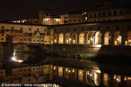 Ponte Vecchio at night, lit arches reflected in the Arno
