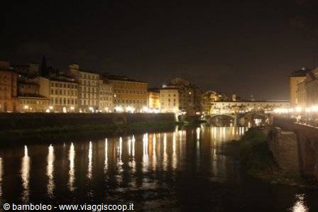Ponte Vecchio lit at night reflected in the Arno, Florence
