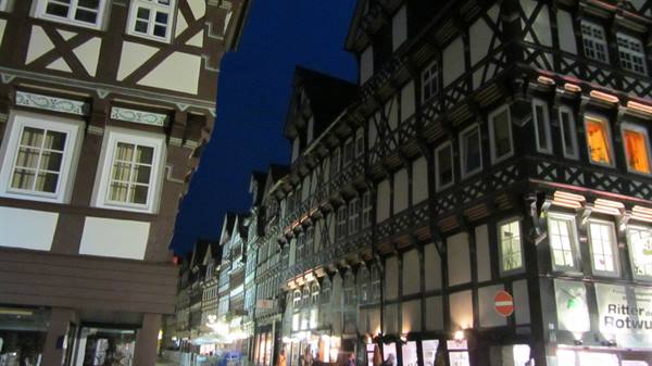 Illuminated half-timbered houses at night, likely Marburg