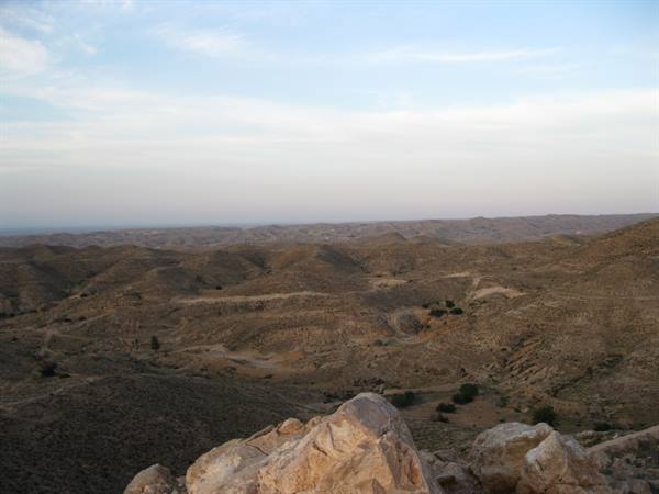 Limestone rock in foreground over dry barren hills stretching to horizon