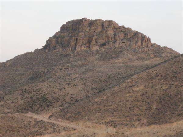 Arid rocky mountain with steep cliffs under soft morning light