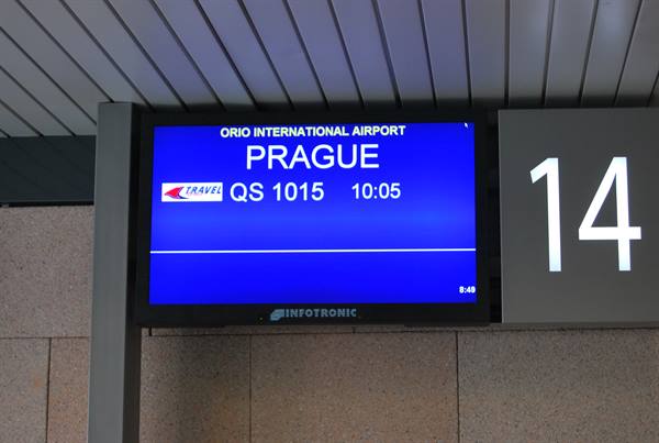 Blue screen at Orio International Airport showing flight QS 1015 to Prague, gate 14