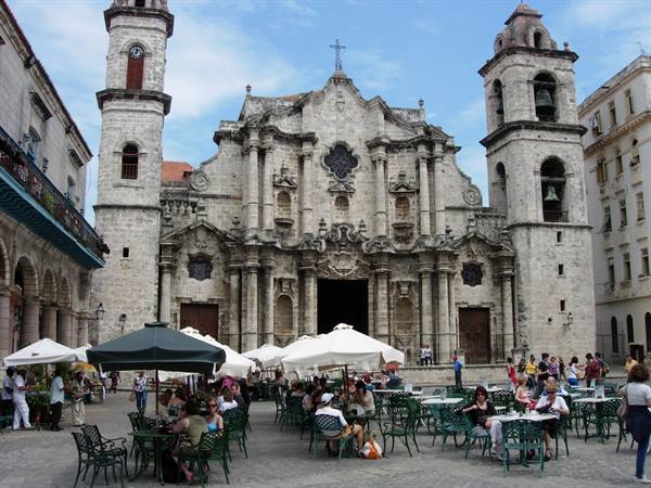 Havana Cathedral: baroque stone facade, café tables with umbrellas on the square