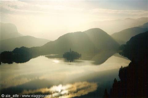 Lake Bled in morning haze, island church reflected on still water