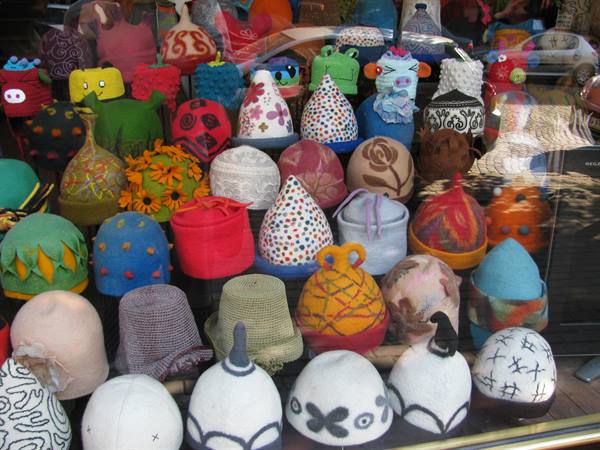 Shop window full of colorful felt hats with decorations