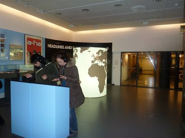 Visitors with headphones at interactive stations in the Nobel Peace Center, Oslo
