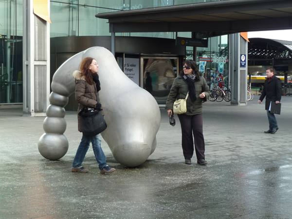 Women beside a curvy metal sculpture outside Oslo Central Station