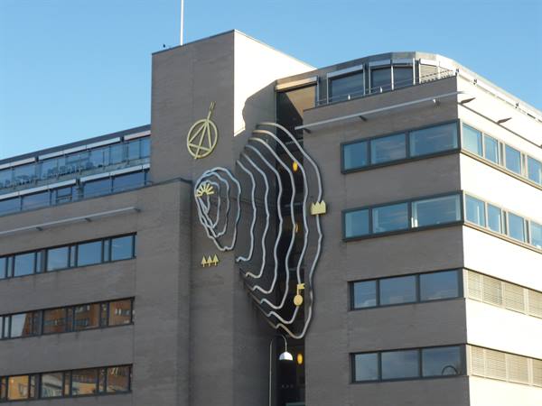 Concrete facade with wavy metal sculpture, modern buildings in Oslo
