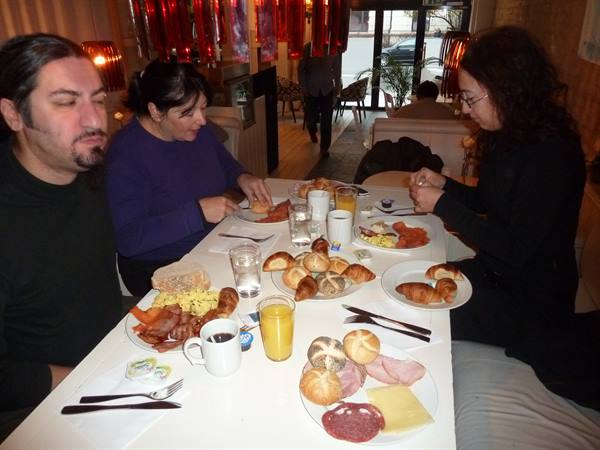 Generous breakfast with croissants and cold cuts on an Oslo hotel table